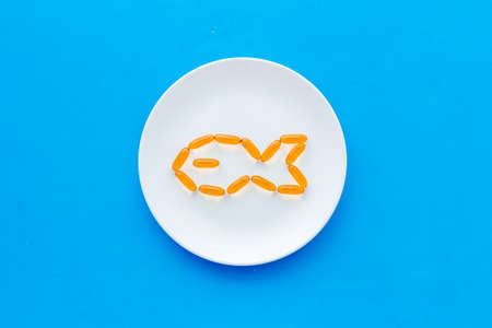 Omega fish oil supplement on plate from aboveの写真素材