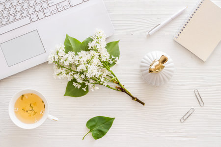 Lauout of computer and jasmine flowers on bright working space. Top view
