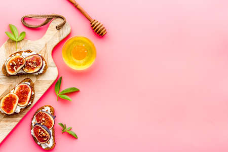 Sandwiches with cheese, fresh figs and walnuts on wooden cutting boardの写真素材