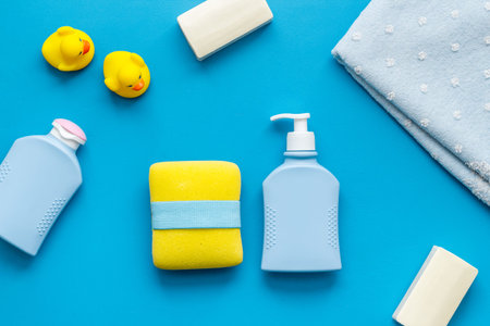 Set of baby hygiene and bath items with shampoo bottle and soap. Top view