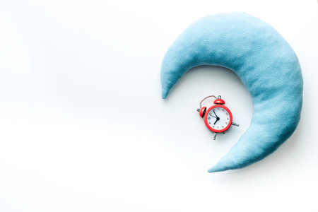Sleeping pillow and alarm clock top view. Sleep disorder stress concept