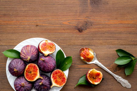 Fresh figs in on a plate with green leaves. Top viewの写真素材