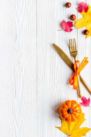 Thanksgiving table setting with cutlery pumpkins and autumn leavesの写真素材