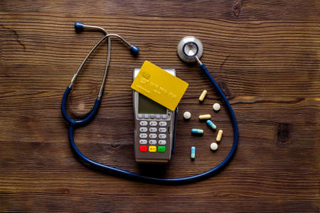 Credit card and payment terminal on doctors table. Healthcare insurance conceptの写真素材