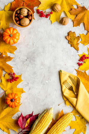 Thanksgiving dinner background with pumpkins leaves and cutlery, top viewの写真素材