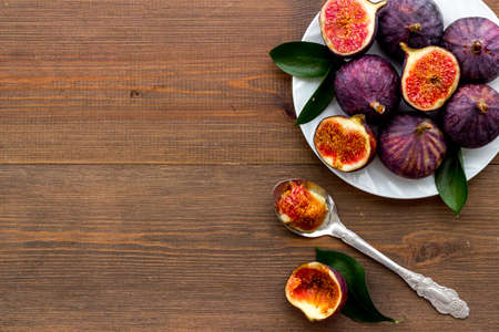 Fresh ripe figs in on plate with leaves. Mediterranean fruit backgroundの写真素材