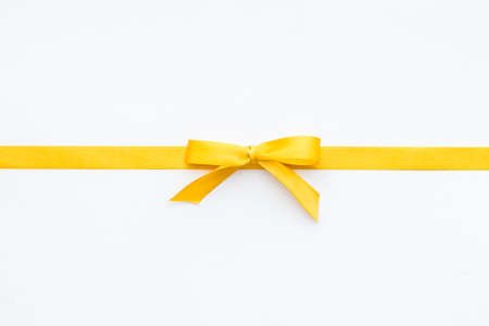 Yellow ribbon bow isolated on white background, top view, copy spaceの写真素材