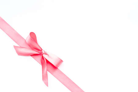 Pink ribbon with bow isolated on white. Top view, copy spaceの写真素材