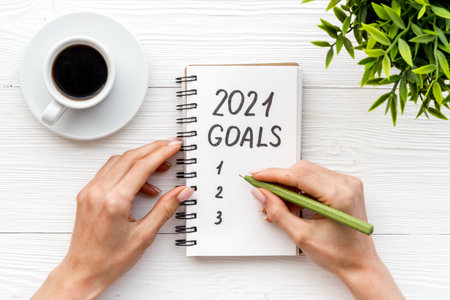 New year goals list. Christmas decorations and notebook on a table, flat layの写真素材