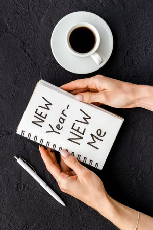 New year - new me. Christmas decorations and notebook on a table, flat layの写真素材