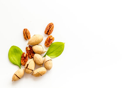 Pile of pecan nuts with leaves. Flat lay, top view