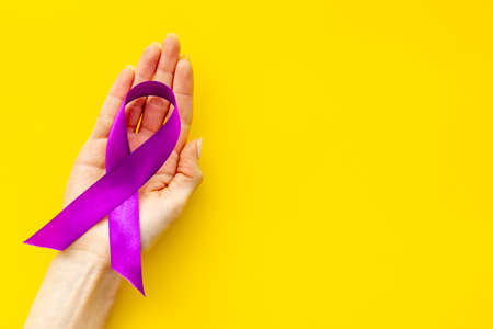 Purple ribbon alzheimers disease pancreatic cancer or epilepsy awareness in hand. Top viewの写真素材