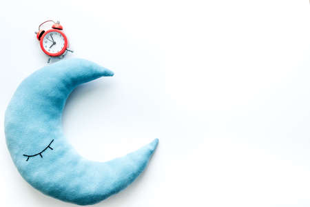 Flat lay of sleeping pillow with alarm clock, top viewの写真素材