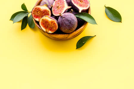 Fresh figs in a bowl with green leaves. Top viewの写真素材