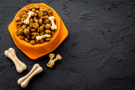 Dry dog food in bowls with bones, top view, copy spaceの写真素材