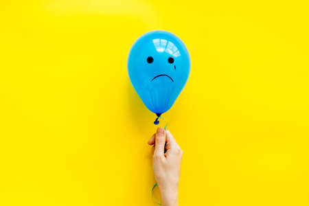 Sadness emotion face on balloon - depression mood background. Top view, copy spaceの写真素材