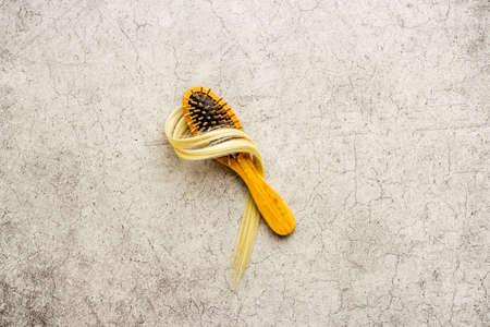 Strand of blond hair wirh hairbrush, flat layの写真素材