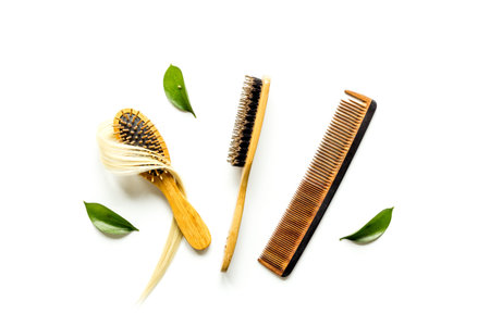 Curl of blond hair with bamboo comb and herbs. Top view flat lay