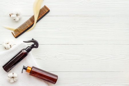 Flat lay of herbal hair care products with lock of blond hair and comb