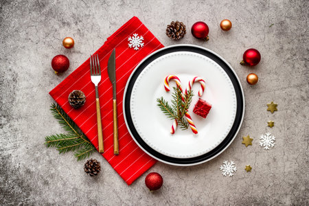 Top view of Christmas table place setting with empty plate and festive decorations