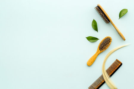 Curl of blond hair with bamboo comb and herbs. Top view flat lay