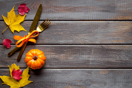 Thanksgiving table setting with cutlery pumpkins and autumn leavesの写真素材