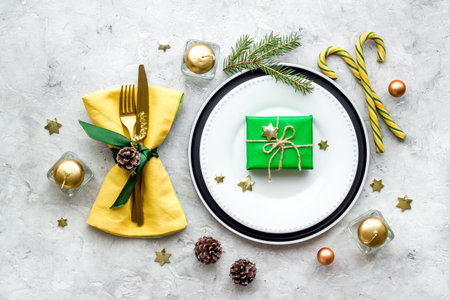 Top view of Christmas table place setting with empty plate and festive decorations