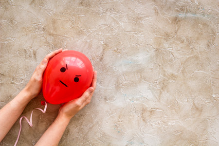 Anger emotion face on balloon - madness mood background. Top view, copy spaceの写真素材