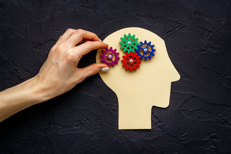 Brain of gears. Hand put peace of puzzles on paper head. Mental works conceptの写真素材