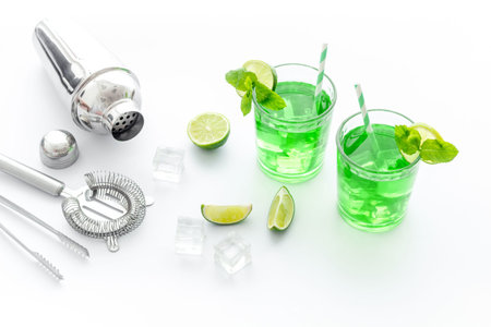 Glasses of iced mojito or lemonade with lime and mint