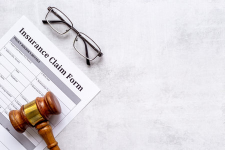 Insurance claim form with judge gavel . Top view
