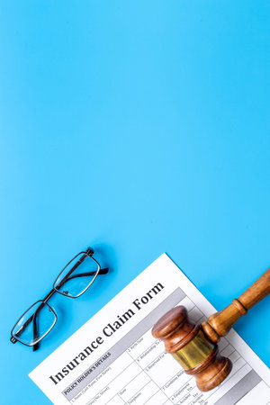 Insurance claim form with judge gavel . Top view