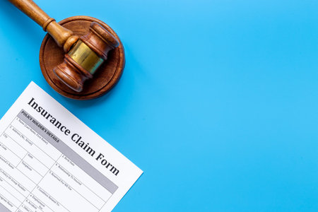 Insurance claim form with judge gavel . Top view