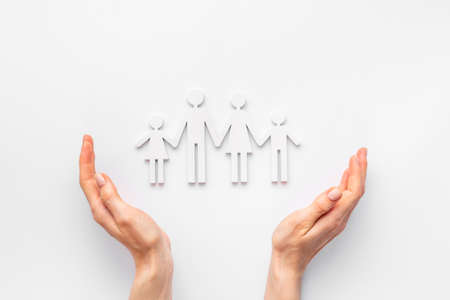 Hands holding family figure top view. Protecting and care conceptの写真素材