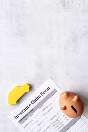 Insurance claim form with car and piggy bank. Top viewの写真素材