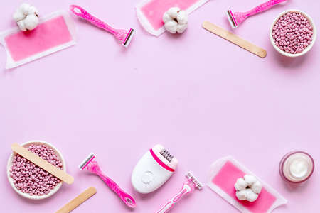Flat lay of pink epilator with wax strips and razor. Spa cosmetic treatments.の写真素材