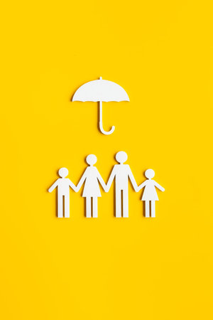 Family figure under umbrella. Insurance and family protection conceptの写真素材