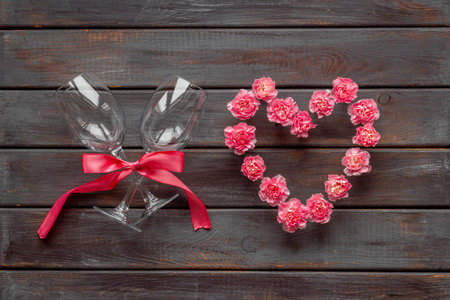 Valentines Day dating dinner with wine glasses and pink flowers. Wedding or birthday background