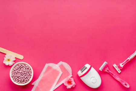 Cosmetics and means for epilation with flowers on pink background, flat layの写真素材