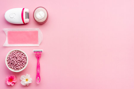 Cosmetics set for epilation with epilator and wax strips and flowers. Top view