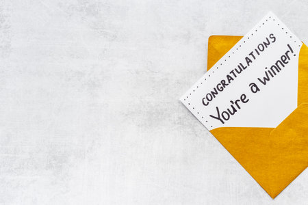 You are a winner. Golden envelope with congratulation card. Top view
