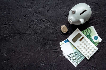 Piggy bank with cash money and calculator. Saving money conceptの写真素材