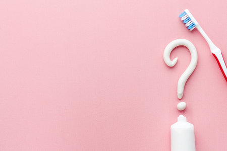 Question mark of toothpaste with toothbrush, top view. Oral care and hygiene