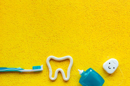 Tooth shape with tube of toothpaste and toothbrush. Dental hygiene concept, top viewの写真素材