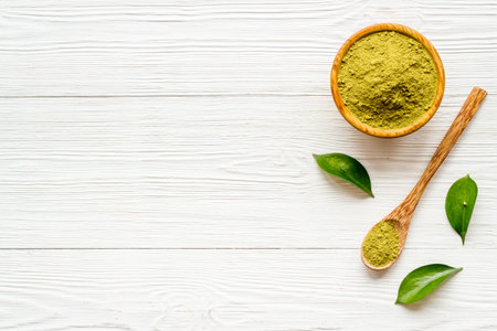Henna powder in wooden bowl with green leaves. Herbal natural hair dyeの写真素材