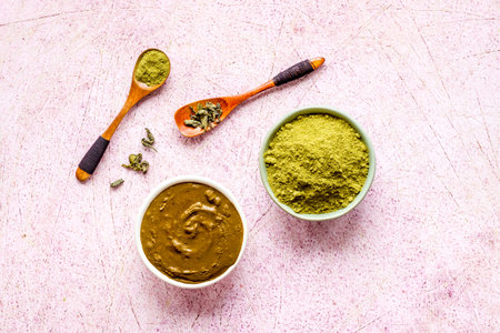 Henna powder in wooden bowl with green leaves. Herbal natural hair dye