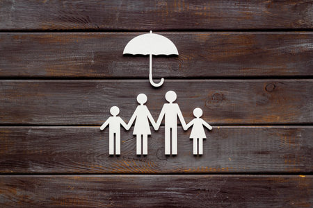 Family figure under umbrella. Insurance and family protection concept
