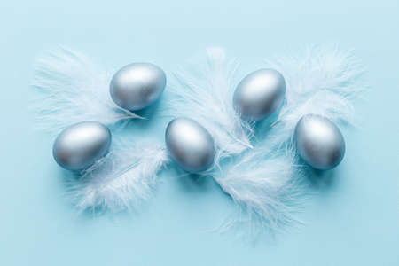 Silver Easter eggs with white feather. Easter decoration, top viewの写真素材