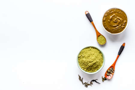 Henna powder in wooden bowl with green leaves. Herbal natural hair dyeの写真素材
