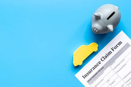 Insurance claim form with car and piggy bank. Top viewの写真素材
